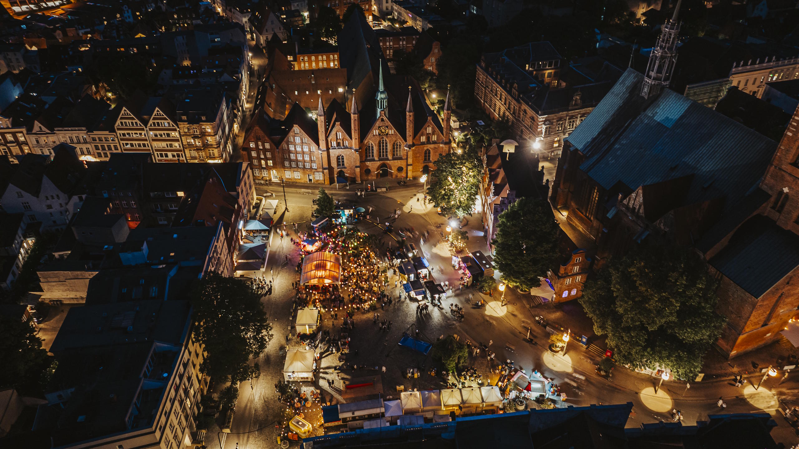 Nächtliche Luftaufnahme eines beleuchteten Festivalplatzes in der Lübecker Altstadt.