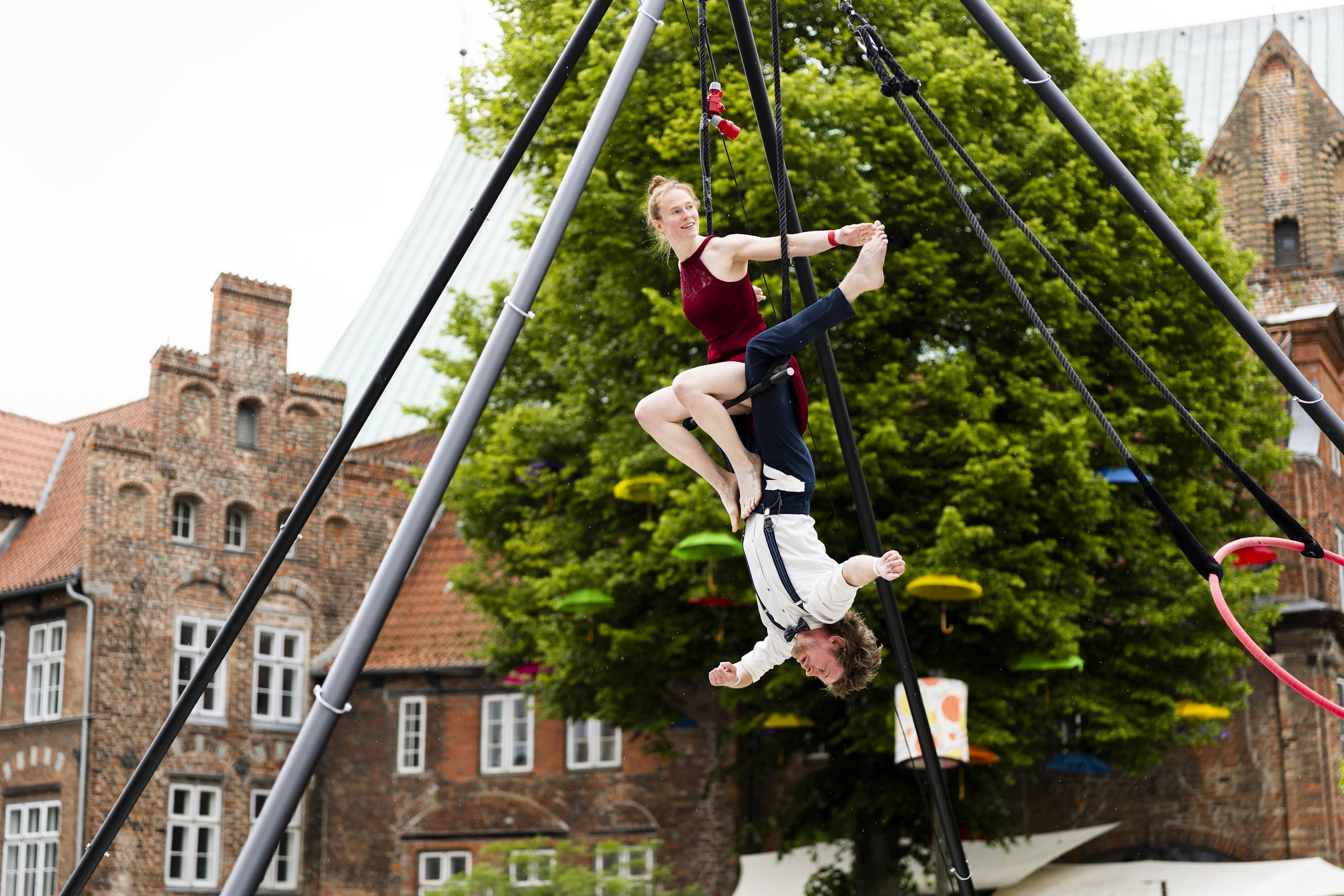 Luftakrobatik-Duo zeigt eine artistische Darbietung vor historischer Kulisse beim HanseKulturFestival in Lübeck.